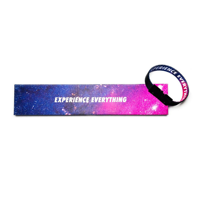 Studio image of Experience Everything clasped together laying on the box it comes in, which has a design of a blended pink and purple space with Experience Everything in white text  