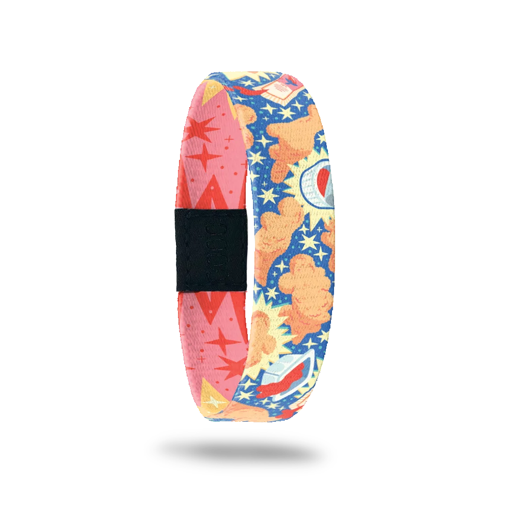 Wristband single with a blue base. The deisign on top is dino nuggets all over with packs of opened ketchup and yellow stars. The inside is a red and pink design of stars and sunbursts and reads Nugs 'N Kisses. This comes with a matching lapel pin and collector's box.