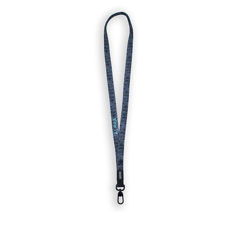 A product image of a ZOX lanyard showing the back of the design with a black colored metal clip. The lanyard is called Alpha and the design is showing the name Alpha in a green font. The background is a lighter grey and black version of the front which is made of geometric shapes closely packed together