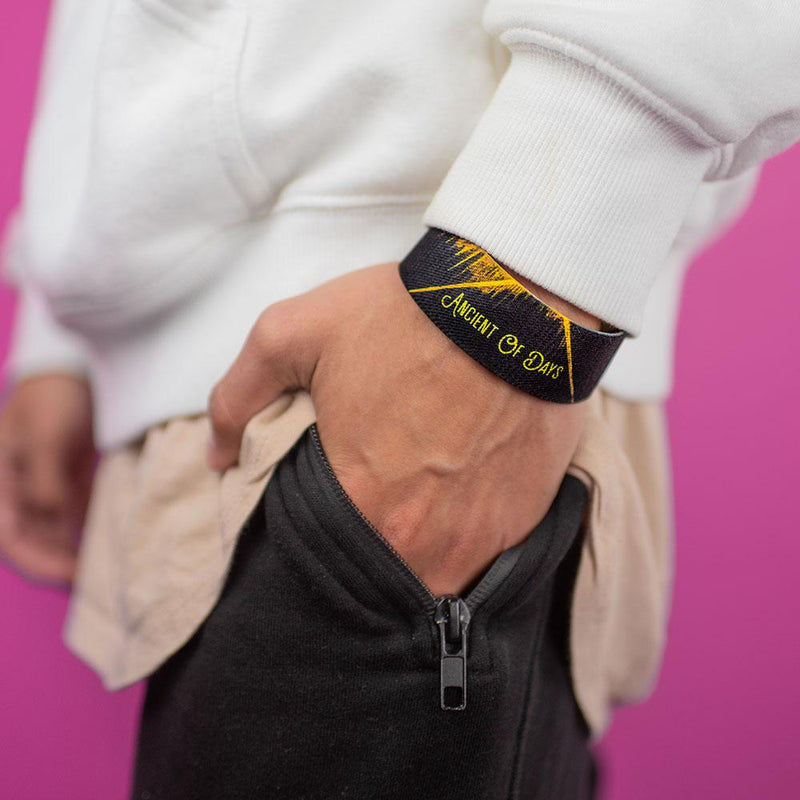 Studio image of hand in pants pocket wearing Ancient Of Days on their wrist