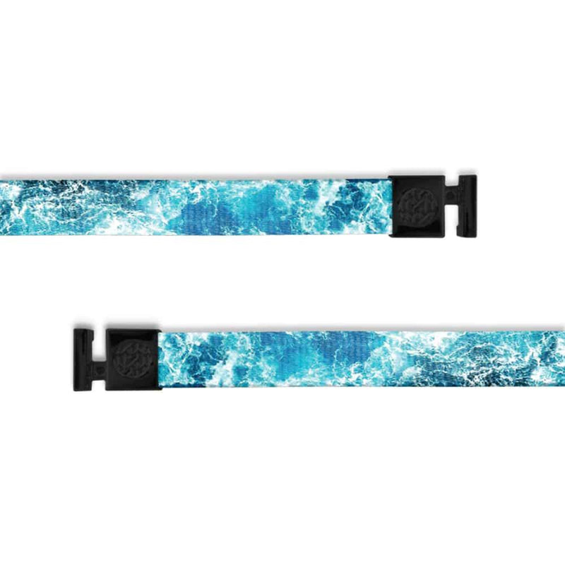 A product image of a wide and flat string with black metal aglets meant to be used with the ZOX hoodie. The string is called Carry On and the design is imagery of waves with an array of blues with a bit of white