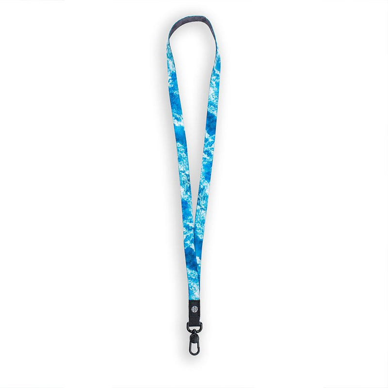 A product image of a ZOX lanyard showing the front of the design with a black colored metal clip. The lanyard is called Carry On and the design is different hues of blue showing an image of wave