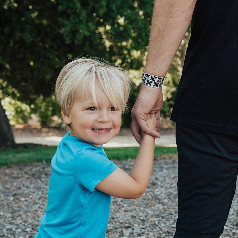 Lifestyle of young boy holding hand of someone wearing Count Your Blessings