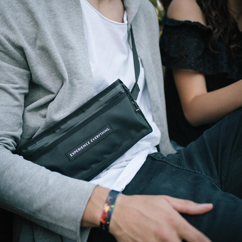 lifestyle photo of a man wearing the fanny pack cross body while sitting next to a woman