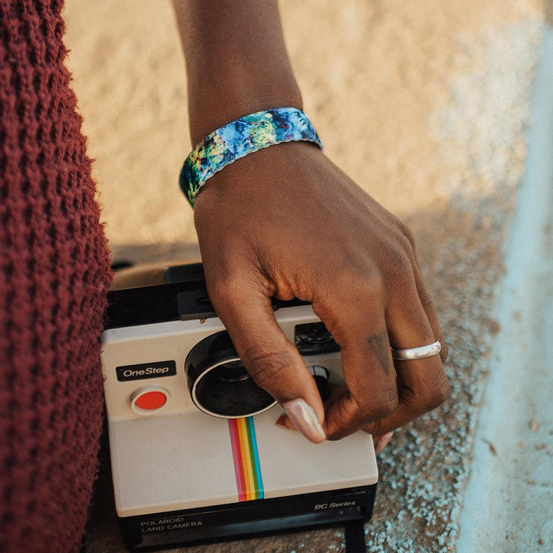 Lifestyle close up image of someone holding a camera and wearing My Empire Of Dirt 