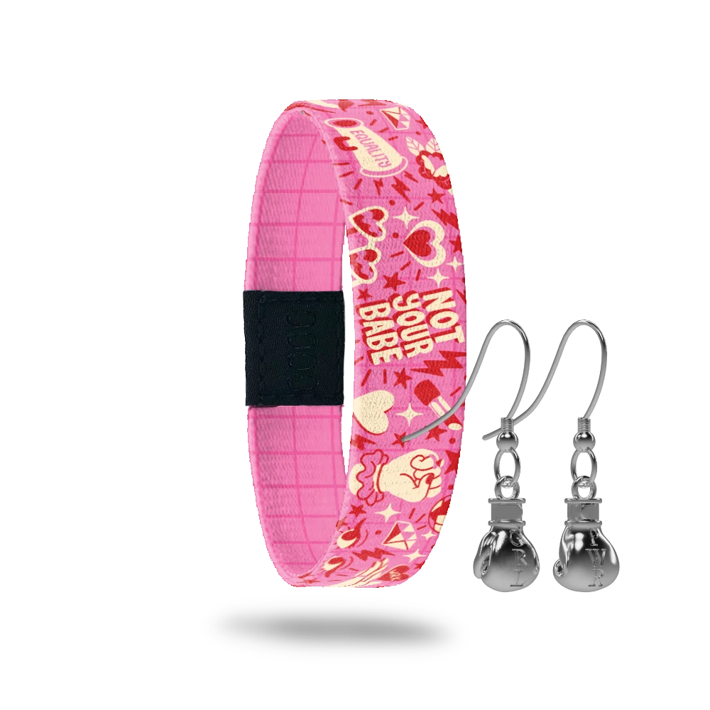 Wristband with pink base and red and offwhite "girl power" phrases and hearts. Inside is a pink base with red pinstripes and reads Fight Like A Girl. Comes with a matching pair of stainless steel boxing glove earrings. 