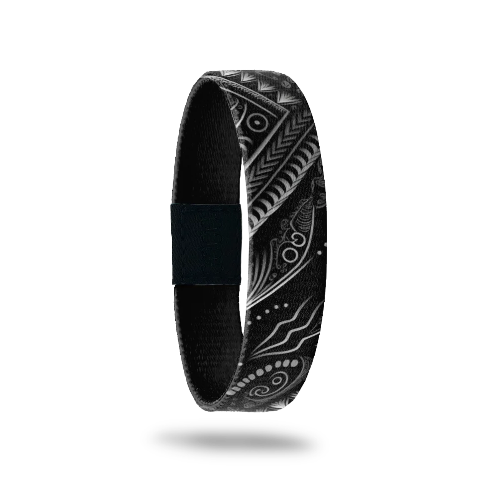 Wristband is black with white geometric and abstract designs. Inside is sold black and reads Get It Done. 