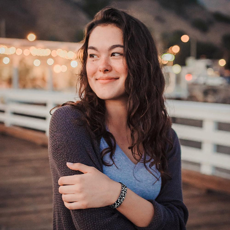 Lifestyle image close up of someone smiling with Gifted on their wrist 