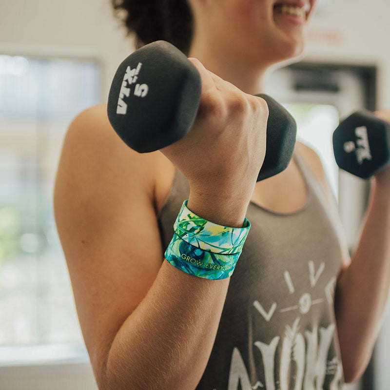 Lifestyle close up of someone doing bicep curls with 2 Grow Every Day on 1 wrist