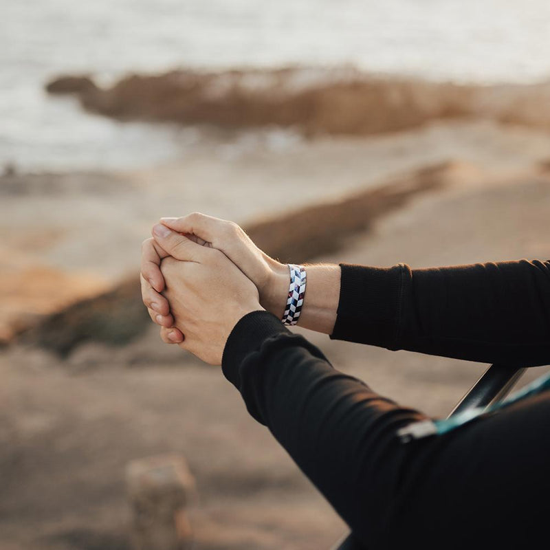 Lifestyle image of arm resting on a railing wearing Hustle