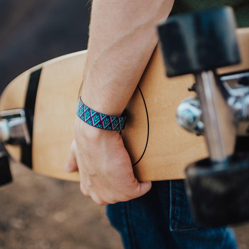 Lifestyle image close up of someone holding a skateboard and wearing Journey