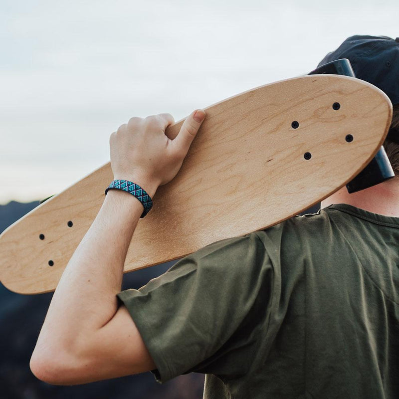 Lifestyle image of someone holding a skateboard and wearing Journey