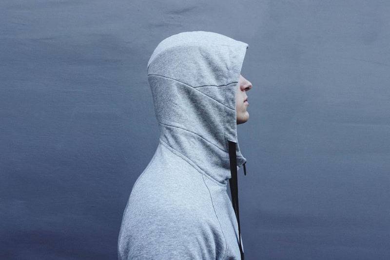 a young males side profile while wearing a lunar grey zip imperial hoodie with the hood up