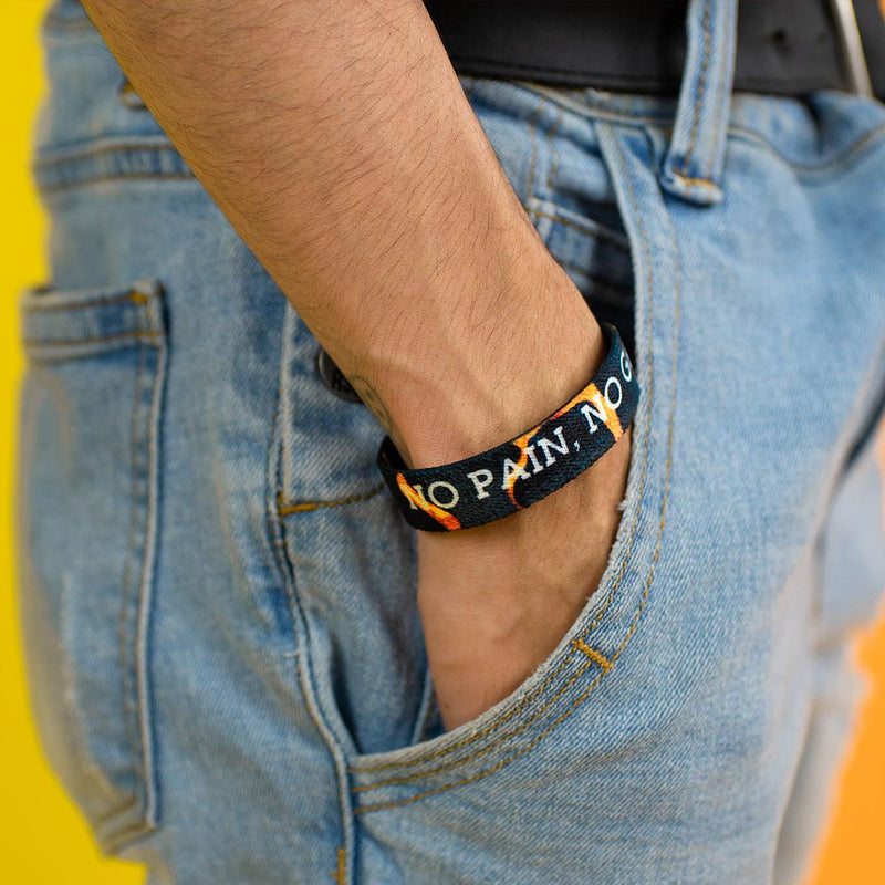 Studio photo of guy with hand in jean pocket showing the inside design of no pain, no pain a white bold text overlaying a black and orange poison dart frog design