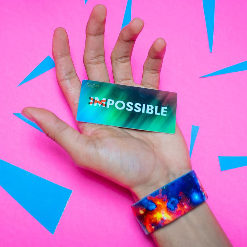 Studio Image of hand holding card that says Possible with a Possible strap on their wrist