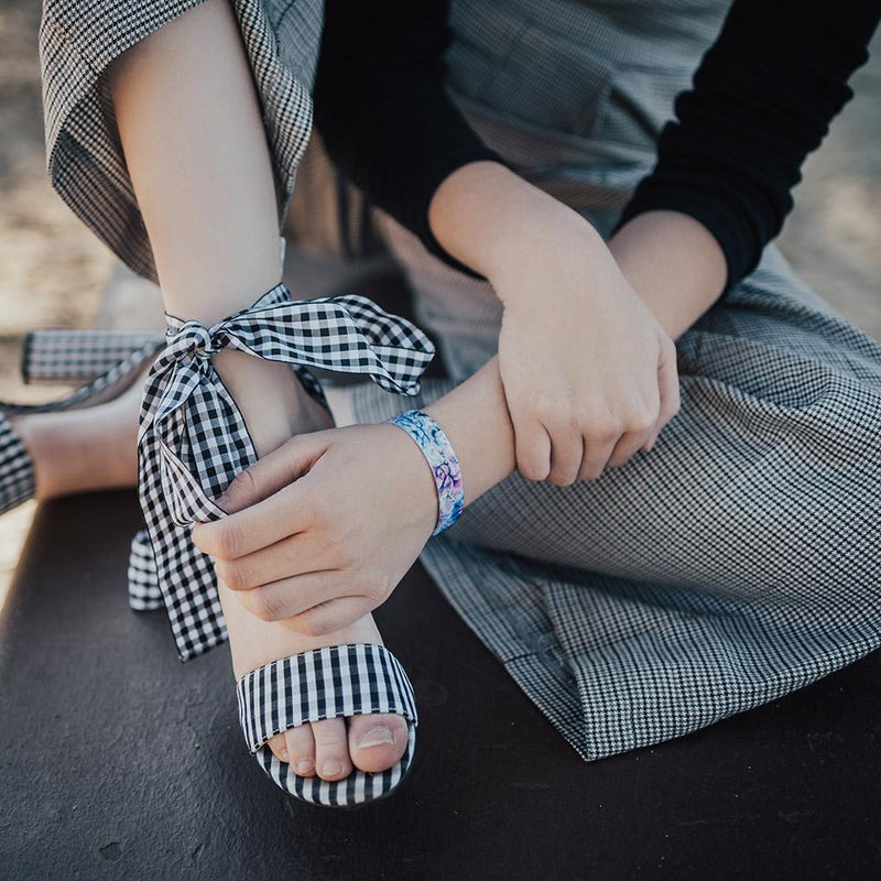 Lifestyle close up image of someone sitting and holding their foot while wearing Perfection