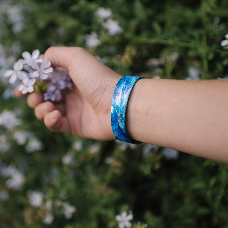 Lifestyle image of someone holding a purple flower and wearing Persistence 