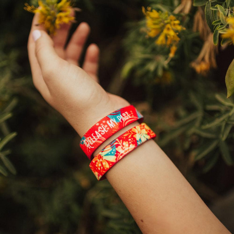 Lifestyle photo of girl reaching out to a flower, showing release my past strap inside and outside of strap.