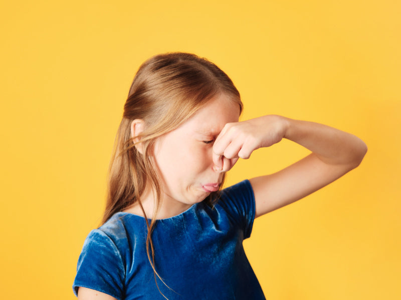 Girl plugging her nose from a bad odor.