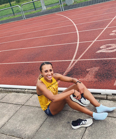 Nadia-Power-sitting-on-running-race-track-and-smiling