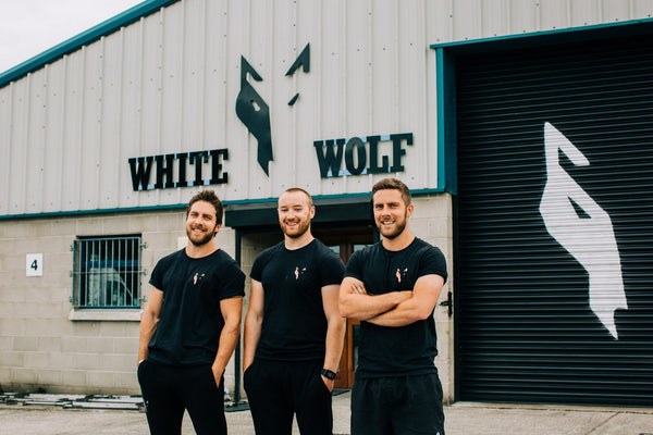 Three men standing outside White Wolf Fitness in Belfast.