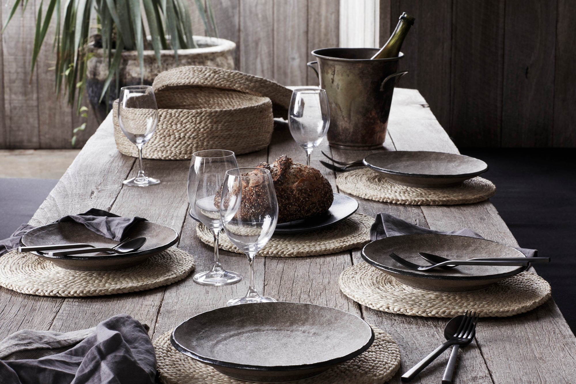 Dark moody table setting with jute placemats and coasters