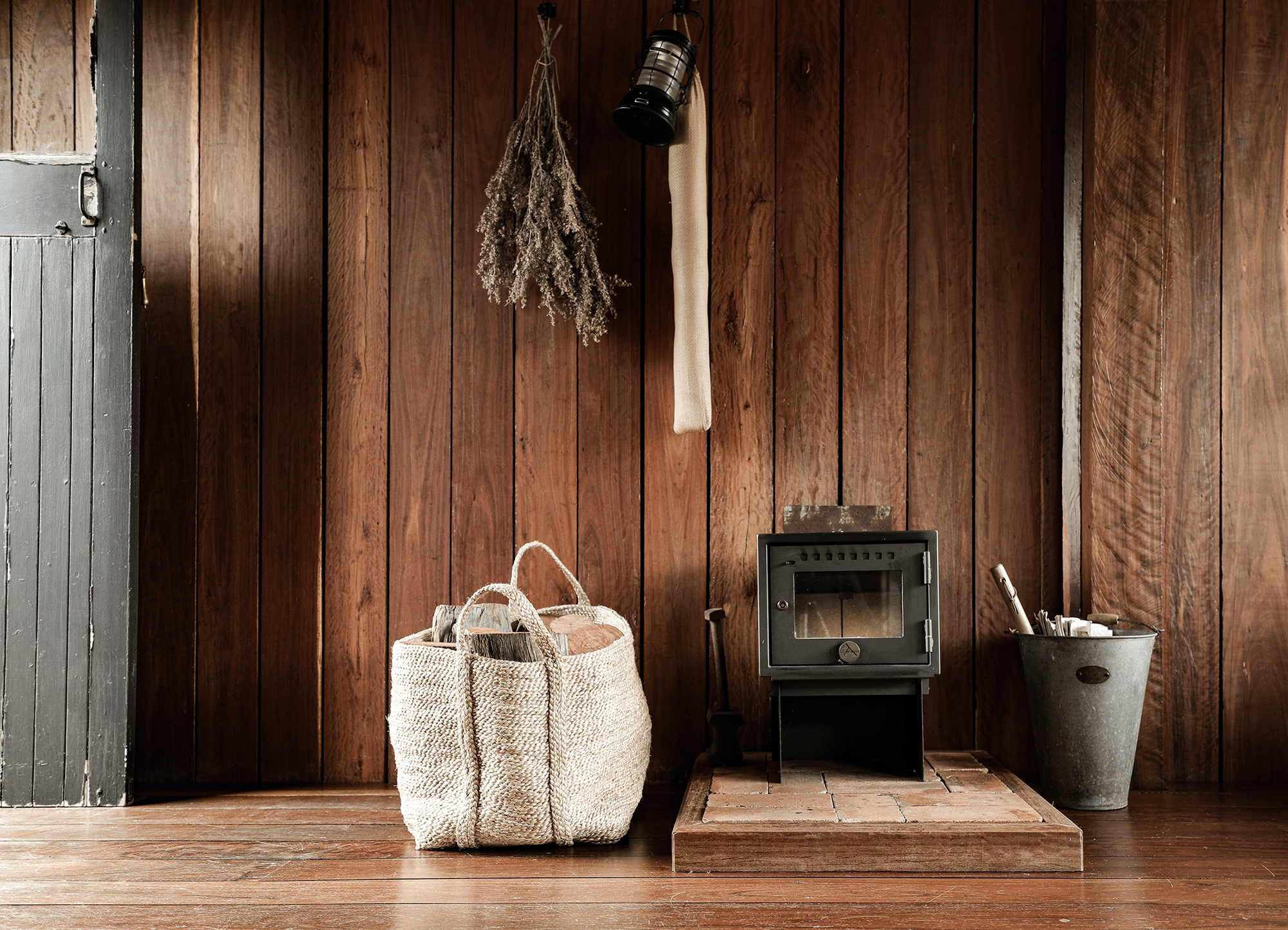 Bloodwood Cabin interior rustic fireplace jute basket with firewood