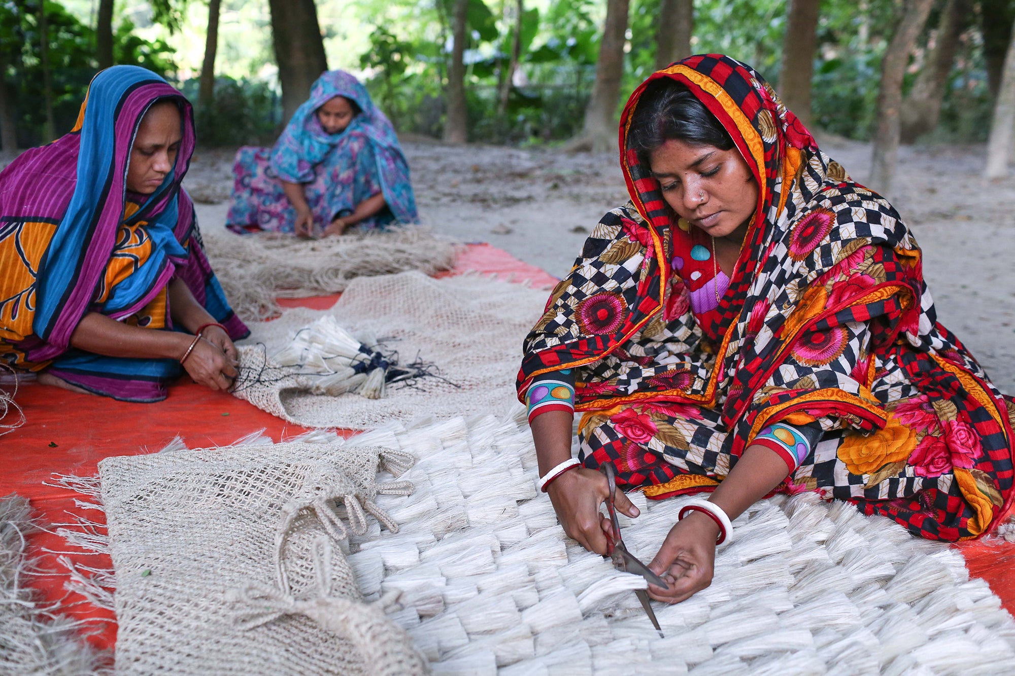 The Dharma Door artisans weaving a tasell wall hanging