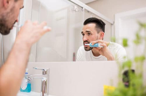 man-brushing-electric-toothbrush