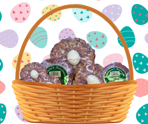 A background of dark and light teal, pale purple, yellow, and pastel red Easter eggs; Large wicker basket front and center of screen, full of 2oz and 1.25oz Pecan Turtles with White Chocolate Easter Eggs