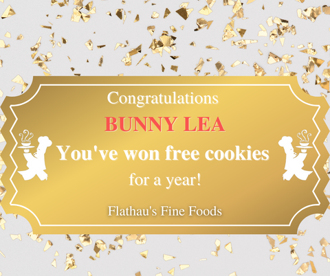 A golden ticket sits on a white background with gold confetti.  Two white silhouettes of a Chef sit turned out on either side of the ticket.  White font on the gold background of the ticket reads: "Congratulations, You've won Free Cookies for A Year.  Flathau's Fine Foods".  Red text reads the winner's name: Bunny Lea
