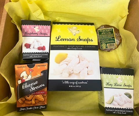 Gift box full of yellow tissue paper containing five items: 6oz Lemon Snaps, 4oz Key Lime Snaps, 4oz Raspberry Snaps, 3.5oz Cheese Straws, 2oz Pecan Turtle