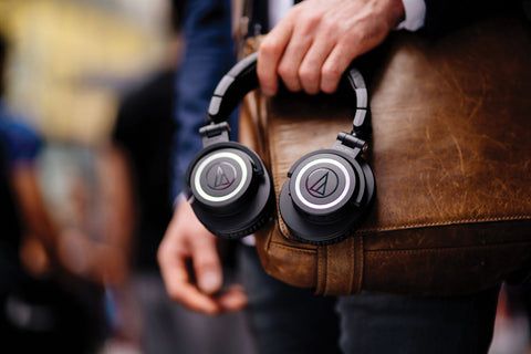Audio-Technica-Kopfhörer gegen braune Schulranzen gehalten