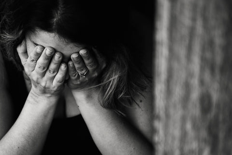 Besorgte Frau mit Gesicht in den Händen