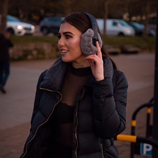 Mujer joven con auriculares EarSnugz grises