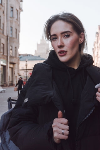 Mujer con abrigo negro en la ciudad