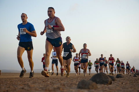 runners running across an arid landscape