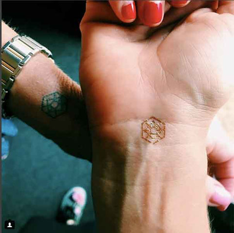 Therapist Krista Kilbane's wrist with a gold mindful mark that represents visualize.