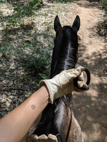 Speech Therapist Tanya Friend sitting on horse wearing center mindful mark.