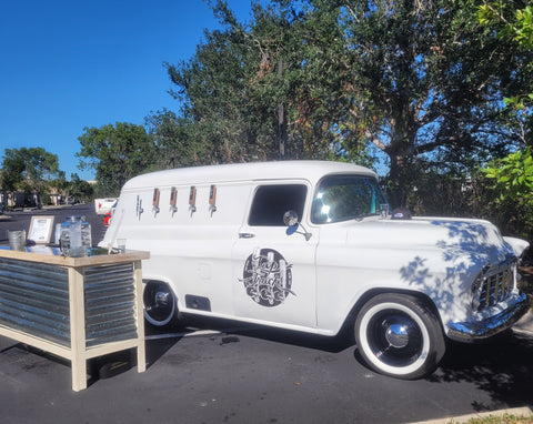 White 1956 Chevy Panel Tap Truck parked and set up at an event.