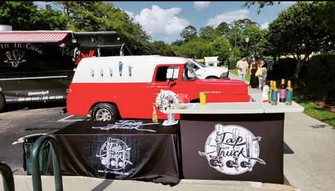 Tap Truck Orlando's Red mobile bar set up at an event, ready to serve beverages.