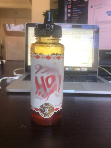 An image of a bottle with a flip cap and nozzle similar to a condiment bottle with the logo blurred out. 