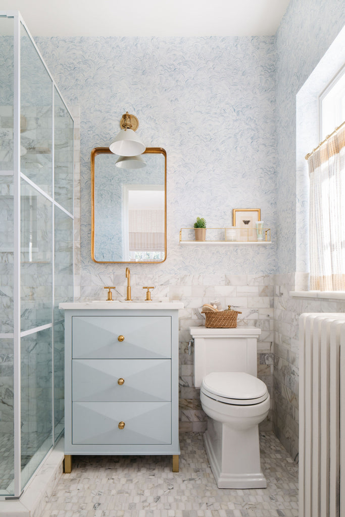 pale blue luxury bathroom with brass accents 