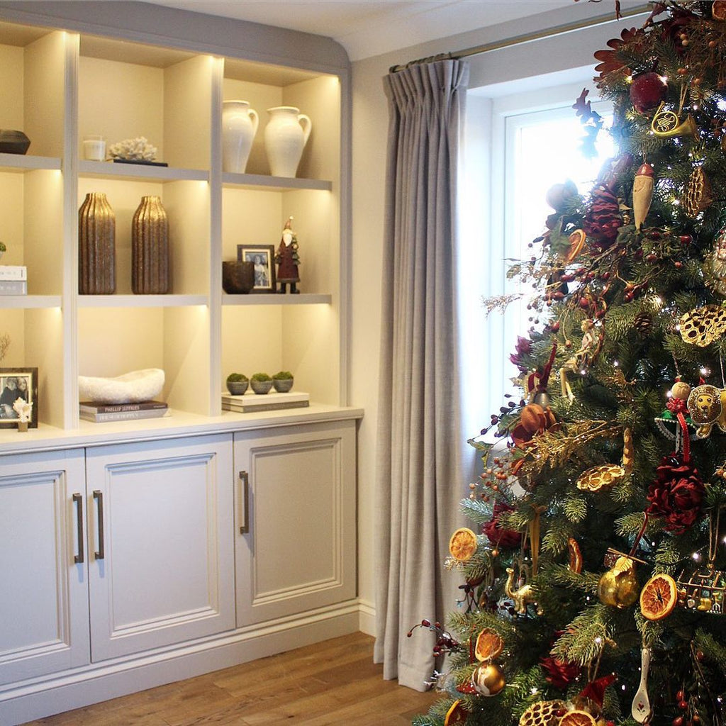 styled built in shelves with warm lighting and traditional christmas tree