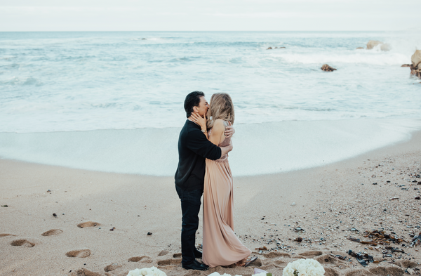 Couple kissing in front of ocean