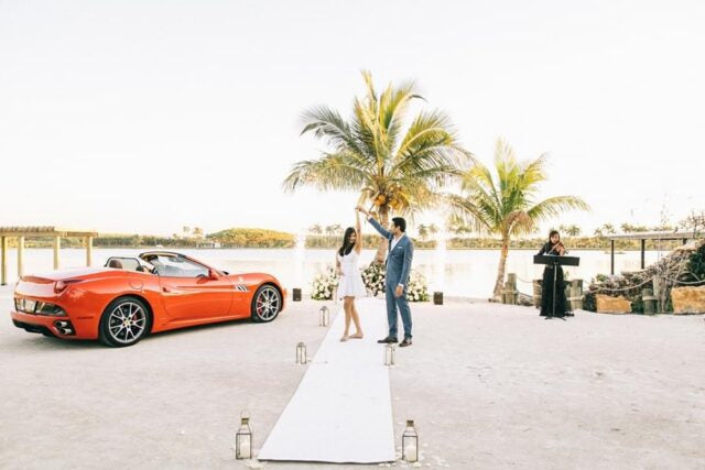 couple engaged with fireworks and red sports car