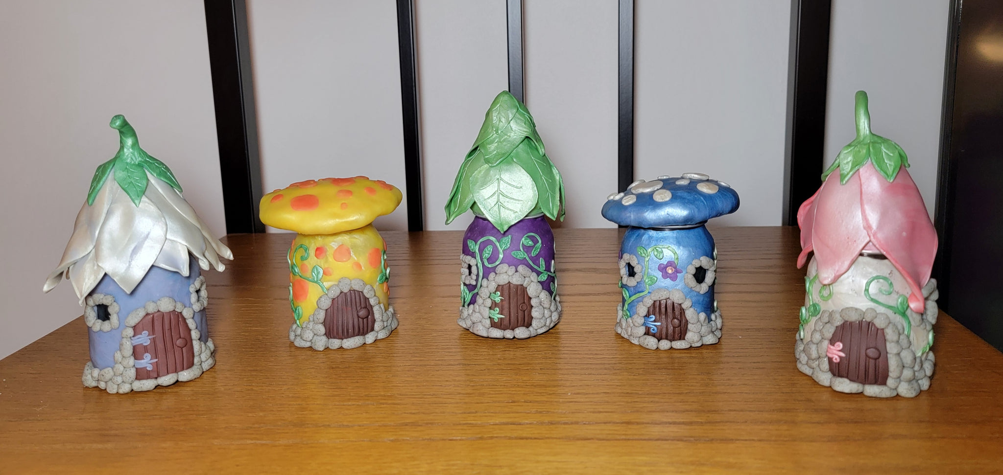 five fairy houses on a shelf