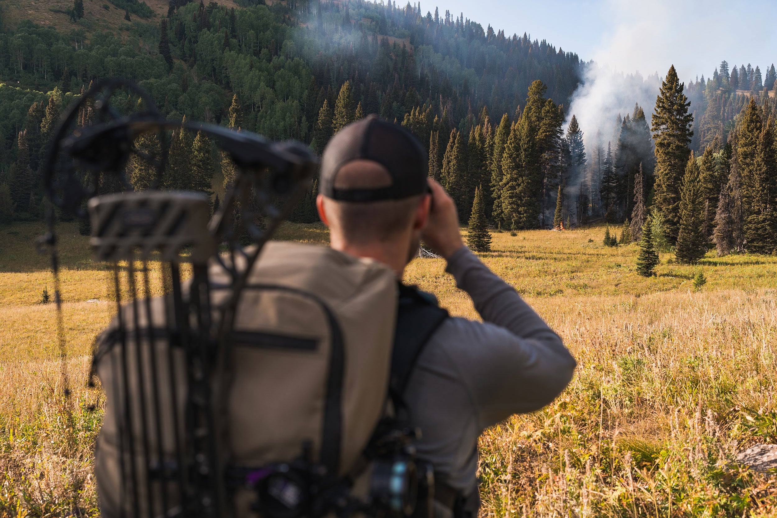 Hunter looking at wildfire through binoculars