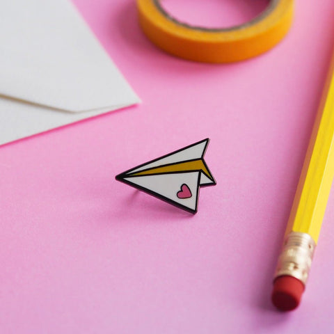 Paper plane enamel pin with a heart 
