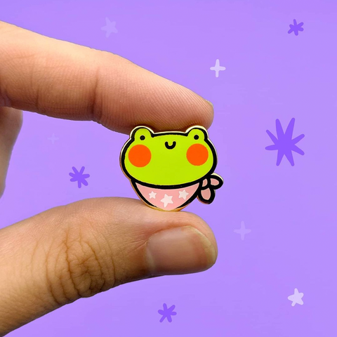 A frog enamel pin with a neck bandana. 